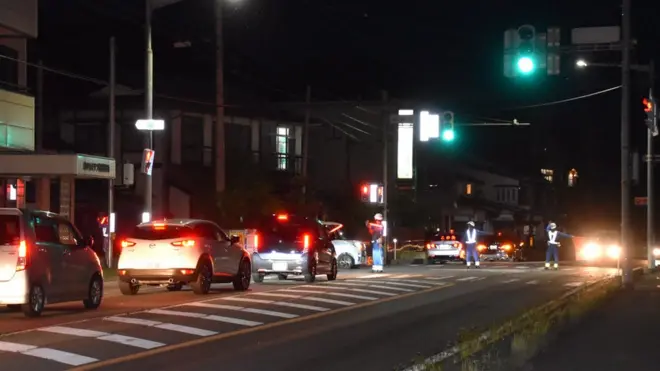 Police officers control access to a street after an armed man barricaded himself in the neighbourhood in Nakano, Nagano prefecture, central Japan,