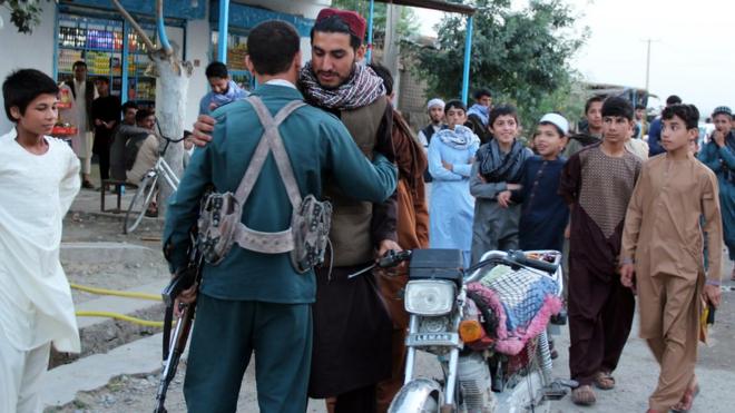 مسلح من طالبان يحتضن جنديا افغانيا