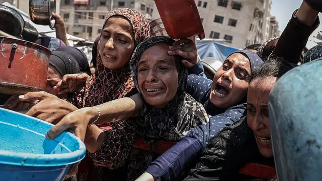 Mujeres tratando de conseguir alimentos en Gaza.