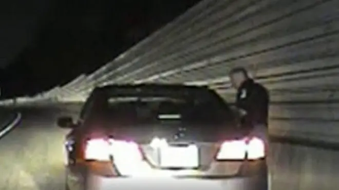 El agente habla con la ocupante del coche.