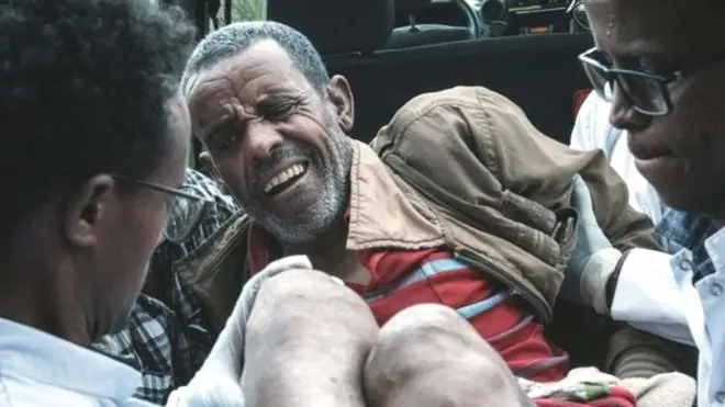 An injured man is carried out of an ambulance by doctors