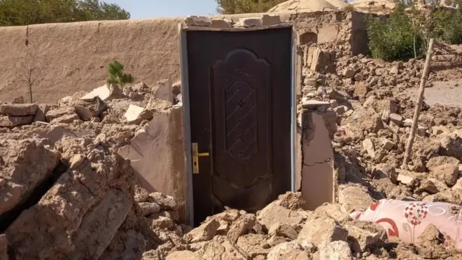 A solitary door is all that remains of a building in Herat after the Saturday's quake