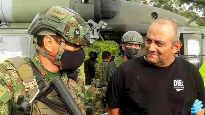 Dairo Antonio Usaga is escorted by police after his capture