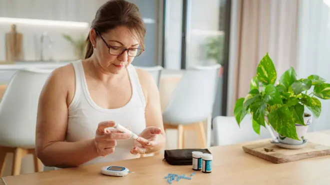 Kan şekerini kontrol eden bir kadın.