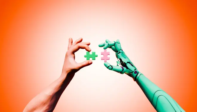 Foto de arquivo de mãos humanas e robóticas a unir peças de puzzle para uma inovação futura