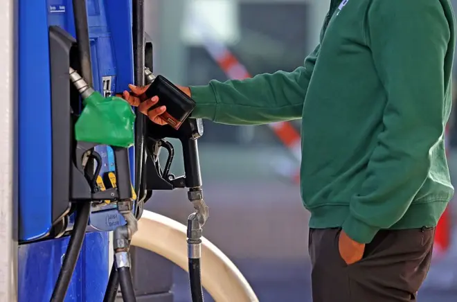  A man inserts his credit card at a petrol pump in Boston