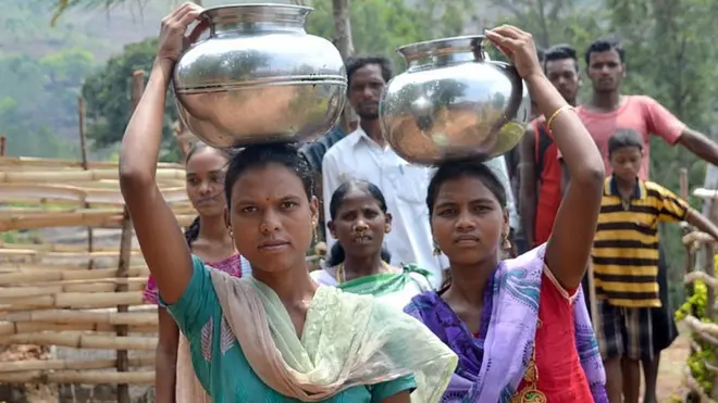 బిందెలలో నీరు మోసుకెళుతున్న గిరిజన మహిళలు