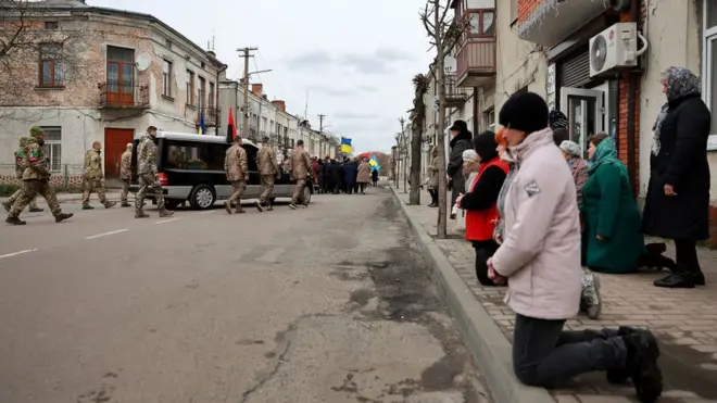Прощання з бійцем загиблим під Попасної у містечку Кам'янка-Бузька. Українці на колінах вшановують загиблих у війні з Росією вояків