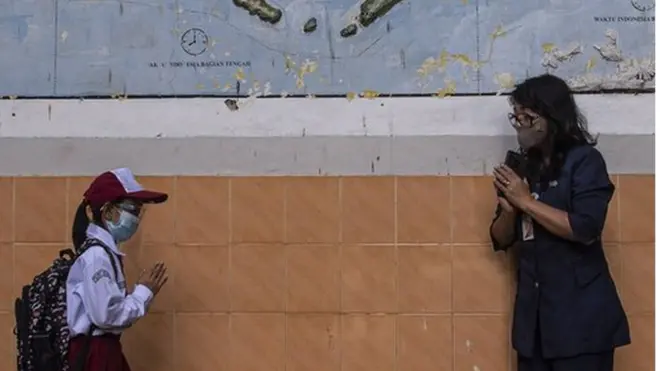 Siswa berpamitan kepada gurunya seusai pembelajaran tatap muka di SDN Pondok Labu 14 Pagi, Jakarta Selatan, Senin (30/08).