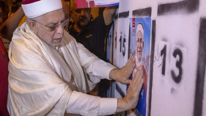 مورو يضع ملصقا دعائيا للانتخابات