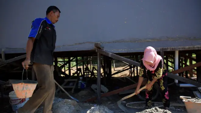 साइट पर काम करते मुस्मुलियादी और उनकी पत्नी नूरमिस