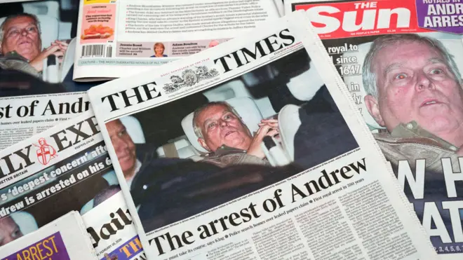 Several UK newspapers spread out showing front pictures of Andrew Mountbatten-Windsor photographed leaving a police station after his arrest