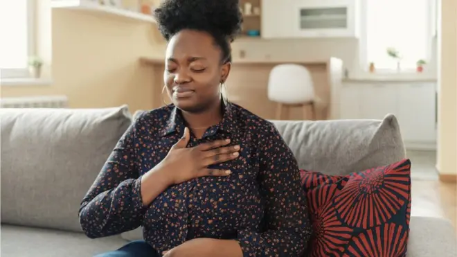 Une femme pose sa main sur le coeur en fermant les yeux