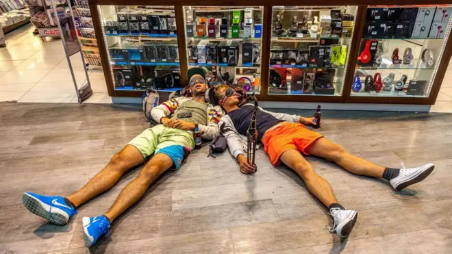 turistas deitados no chão com artefatos de viagem e cervejas