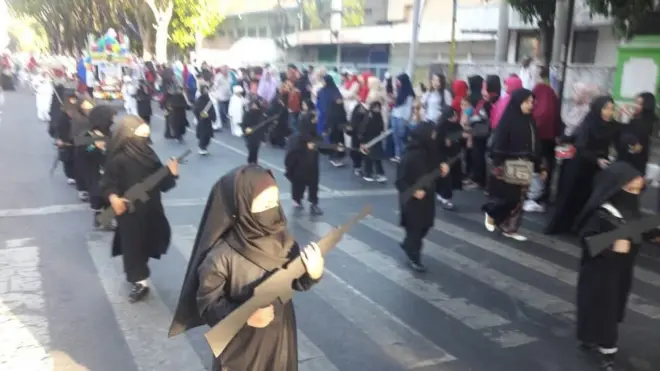 Kehadiran murid-murid TK dengan atribut seperti ini sebelumnya menuai kritik setelah seorang pengguna media sosial mengunggah video pendek dan fotonya di Twitter dan Facebook.