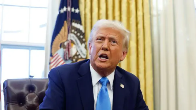 صورة للرئيس دونالد ترامب وهو يجلس إلى مكتبه متحدثا