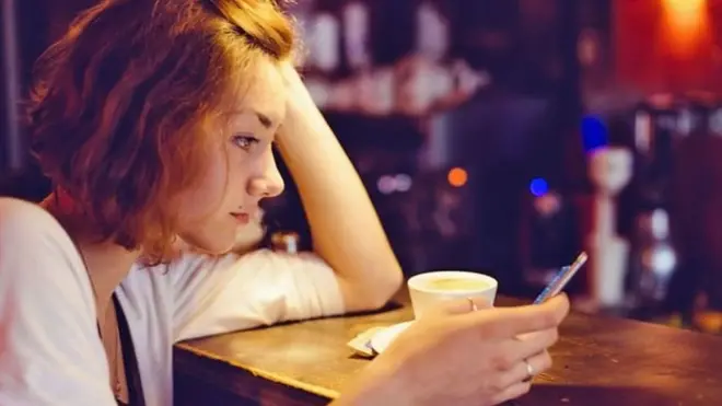 امرأة تمسك بهاتفها