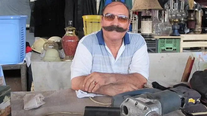 Bu satıcı diqqəti təkcə malları ilə deyil, həm də bığları ilə cəlb edir.