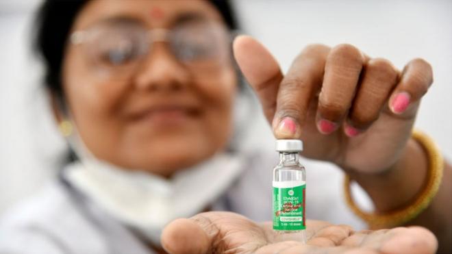 A health worker shows a COVISHIELD dose manufactured by the Serum Institute of India
