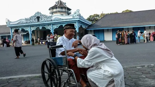 Seorang perempuan mencium tangan orang tuanya seusai melaksanakan salat Idulfitri 1444 H di halaman Keraton Kasunanan Surakarta Hadiningrat Solo, Jawa Tengah, Jumat (21/04). Panitia setempat menggelar dua kali pelaksanaan salat Idulfitri 1444 H yaitu pada Jumat (21/04) dan Sabtu (22/04).