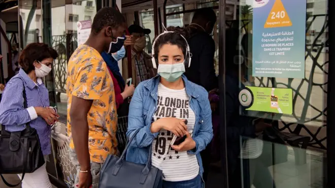 A woman wearing a protective mask steps off a tram in the center of the Moroccan capital Rabat on June 16, 2020.