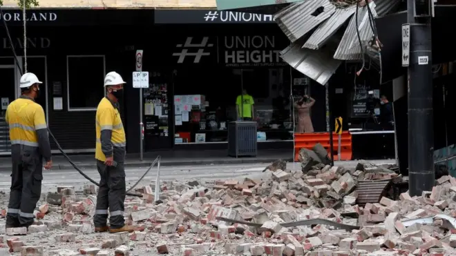 Emergency and rescue officials examine a damaged building in the popular shopping Chapel Street in Melbourne on September 22, 2021, after a 5.9 magnitude earthquake