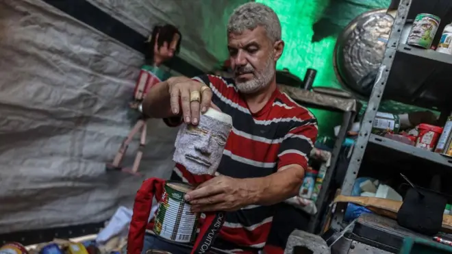 Mahdy Krira avec l'une de ses marionnettes en boîtes de conserve.