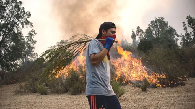 Las fotos de chilenos intentando apagas enormes llamaradas con pequeños artefactos han sido motivo de polémica.