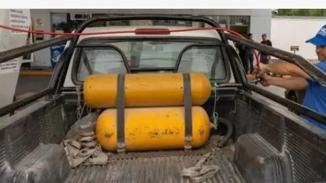 Aworan ọkọ kan ti wọn ko garawa afẹfẹ idana si, pẹlu ẹni to n fa a .