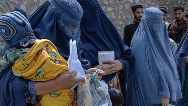 Afghan women receive food donations as part of the World Food Programme (WFP) for displaced people, during the Islamic holy month of Ramadan in Jalalabad on April 20, 2021
