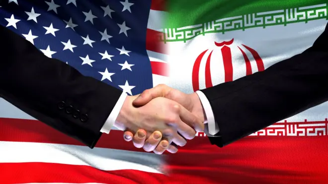 يدان تتصافحان على خلفية العلمين الأمريكي والإيراني