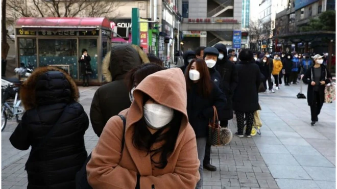 마스크를 받기 위해 줄 서 있는 사람들