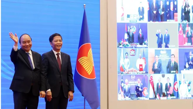 Vietnam"s Prime Minister Nguyen Xuan Phuc (L) and Minister of Industry and Trade Tran Tuan Anh (R) cheer after the virtual signing ceremony for the Regional Comprehensive Economic Partnership (RCEP) in Hanoi, Vietnam, 15 November 2020.