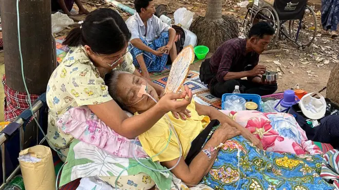 Une femme allongée sur le sol reçoit des soins médicaux