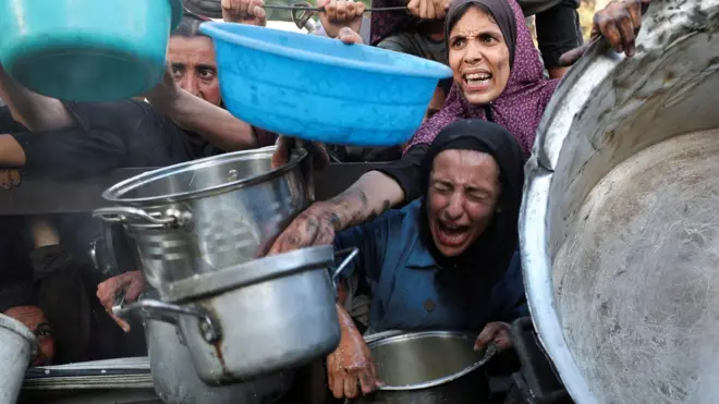 سيدات في غزة يحاولن الحصول على مساعدات غذائية