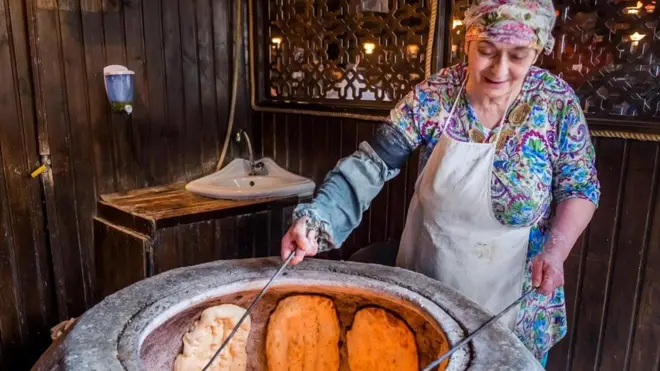 Seorang perempuan menyiapkan roti pipih naan di salah satu restoran di Baku, yang berada di Semenanjung Absheron.