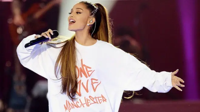 Ariana Grande tampil mengenakan kaos bertuliskan One Love Manchester.