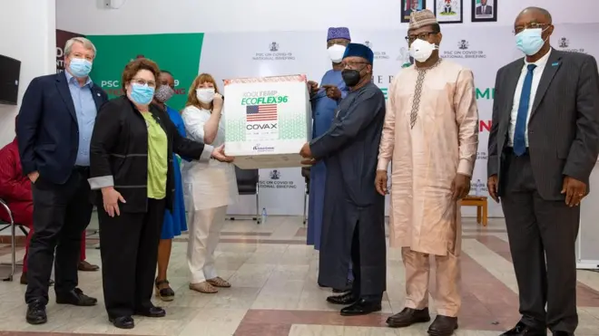 Awọn oṣiṣẹ ileeṣẹ Amẹrika ni Naijiria n ṣe afihan abẹrẹ ajẹsara ti wọn fun Naijiria