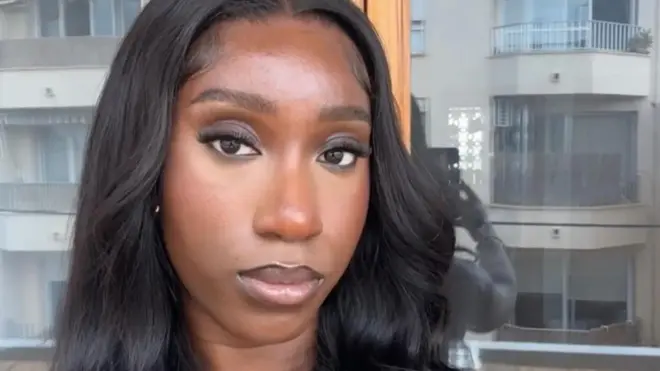 Theresa a 24-year-old woman taking a selfie with a neutral expression