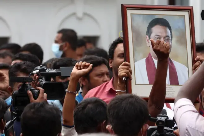 Pro-government supporters hold Prime Minister Mahinda Rajapaksa's portrait while protesting outside the prime minister’s residence on May 09, 2022 in Colombo, Sri Lanka. Sri Lankan President Gotabaya Rajapaksa has declared a state of emergency following escalating anti-government protests. Supporters of Sri Lanka’s ruling party have stormed a major protest site in Colombo, attacking anti-government demonstrators and clashing with police. Dozens of protesters have been injured.