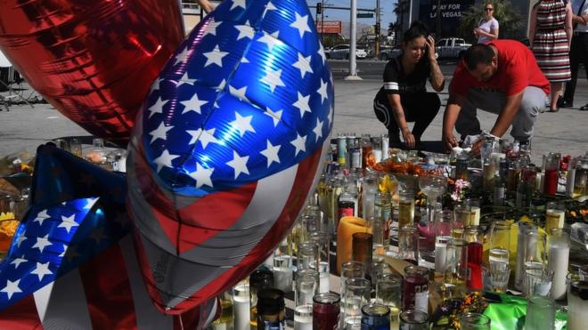 People light candles and pray at a makeshift memorial on the Las Vegas Strip in Las Vegas, Nevada on October 3, 2017