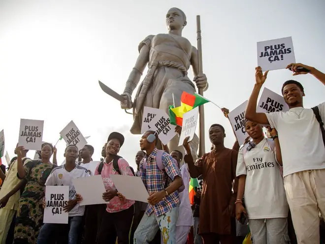 De jeunes étudiants et influenceurs ont défilé avec le drapeau béninois et des pancartes sur lesquelles était inscrit « Plus jamais ça » sur le front, sur l'Esplanade de l'Amazone à Cotonou, au Bénin, le 13 décembre 2025.