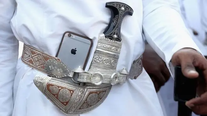 مواطن عربي يحمل هاتفا محمولا