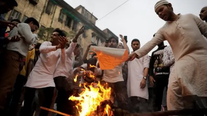Penduduk membakar patung Perdana Menteri Narendra Modi di Kolkata, India.