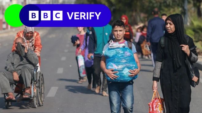 Three Palestinians walking in a line along the evacuation road