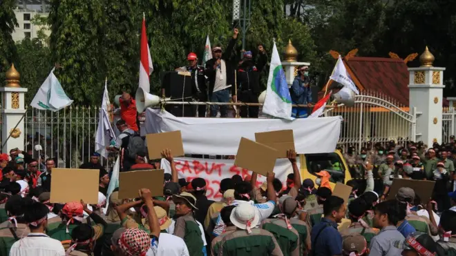 Ribuan massa dari Serikat Pekerja Seluruh Indonesia Riau berunjuk rasa di depan Kantor Gubernur Riau di Pekanbaru, Senin (23/10).