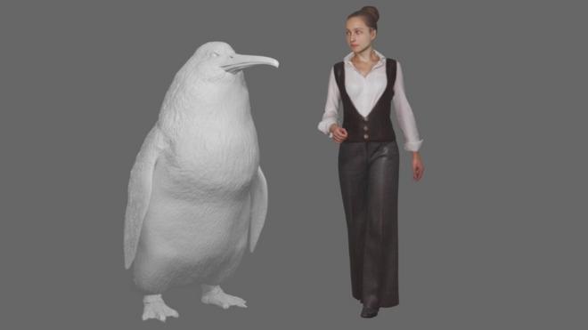 Modelo de pinguim gigante ao lado de mulher