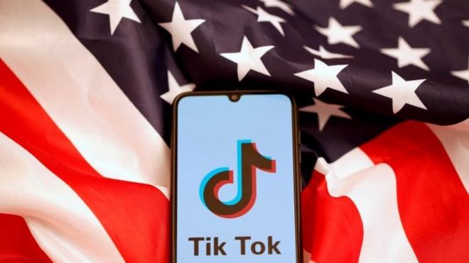 TikTok"s logo is displayed on the smartphone while standing on the U.S. flag in this illustration picture taken, November 8, 2019.
