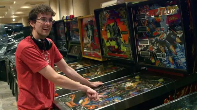 Robert Gagno with a pinball machine