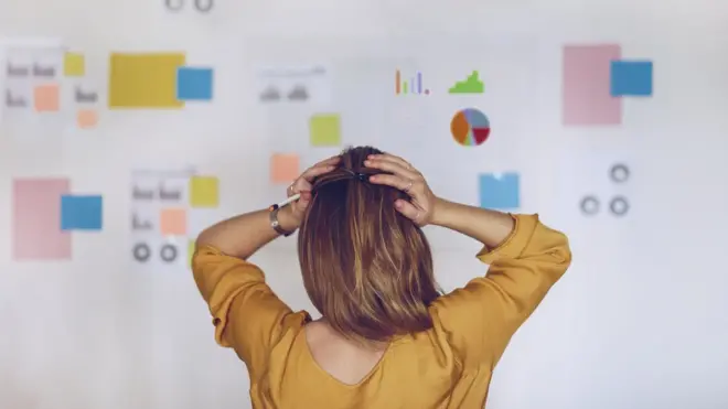 Mujer con manos en la cabeza ante mucha información